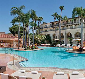 resort pool with white beach chairs and palm trees