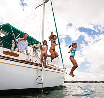 little kids jumping off of sailboat